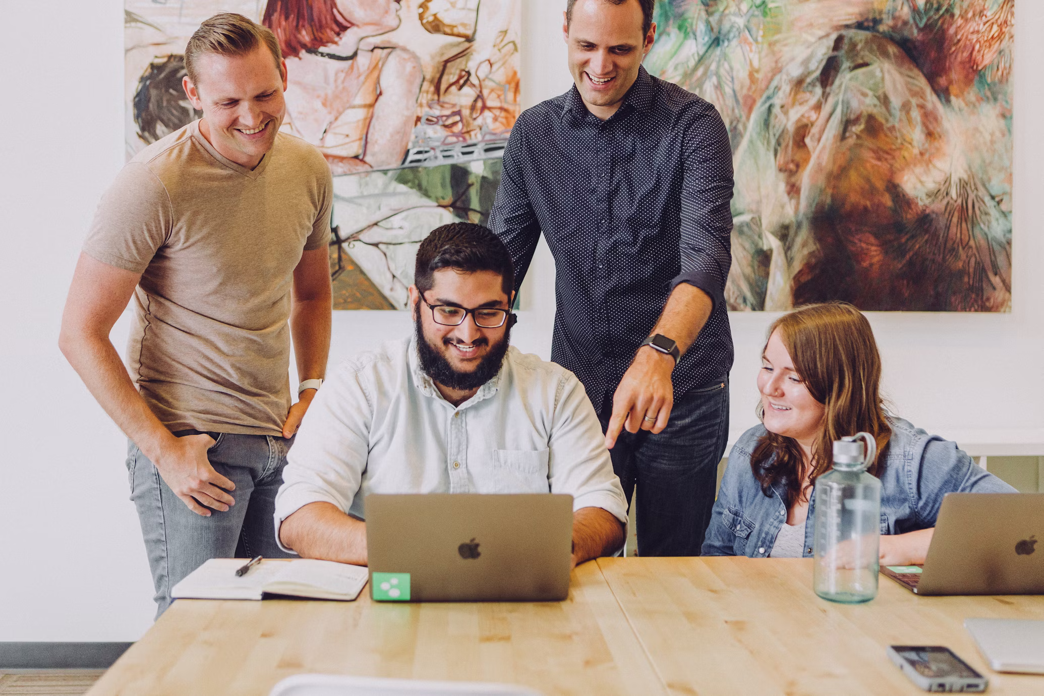 Group of co-workers reading an article online about ai coaching